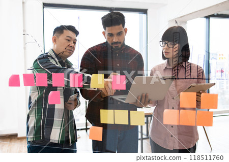 Creative team brainstorming with sticky notes and laptops 118511760