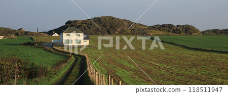 A white house surrounded by green meadows and fields, Rogaland, Norway. 118511947