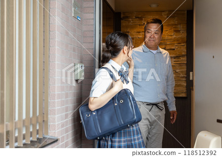 一位父親在門口送讀高中的女兒 118512392