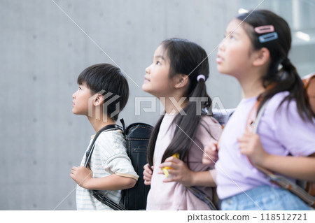 Elementary school students looking up with their school bags on 118512721