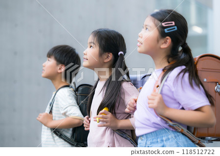 Elementary school students looking up with their school bags on 118512722