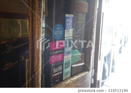 Many stickers on the door of a pub Many stickers on the door of a pub 118513194