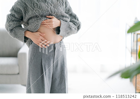 Woman touching her stomach Woman touching her stomach 118513242