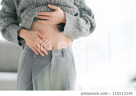 Woman touching her stomach Woman touching her stomach 118513245