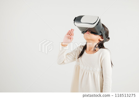 Portrait Asian smiling kid girl touching at something in a virtual reality glasses headset studio shot isolated white background, Excited happy kindergarten child using VR play simulation game 118513275