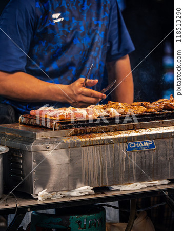 Person Grilling Meat on a Champ Griddle Person Grilling Meat on a Champ Griddle 118513290