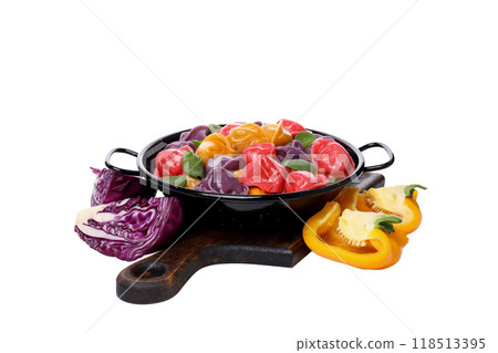 PNG, Colored dumplings in frying pan on board and vegetables isolated on white background 118513395