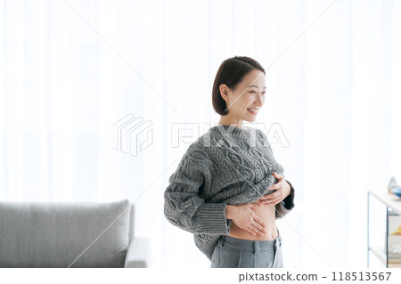 Woman touching her stomach Woman touching her stomach 118513567