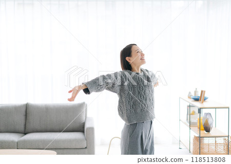 A woman in her 30s stretching at home A woman in her 30s stretching at home 118513808