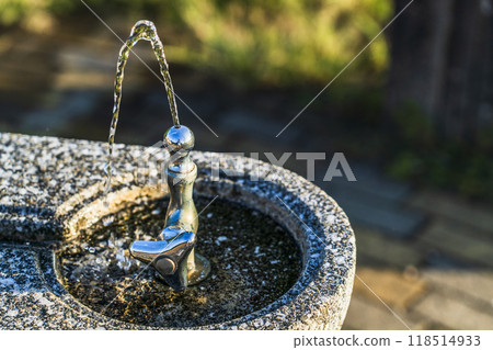 A standing water tap at a drinking fountain in a park A standing water tap at a drinking fountain in a park 118514933