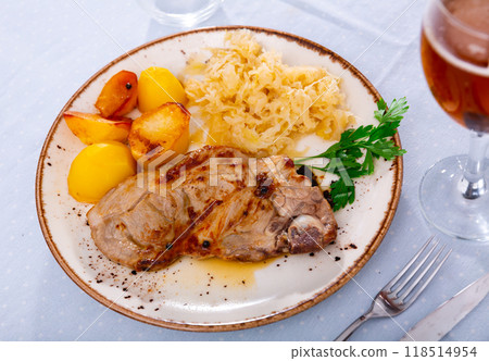 Image of delicious appetizing dish of pork with pickled cabbage and fried potatoes on plate Image of delicious appetizing dish of pork with pickled cabbage and fried potatoes on plate 118514954
