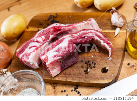 Fresh raw pork ribs with potatoes, onions and black pepper on wooden table 118515194