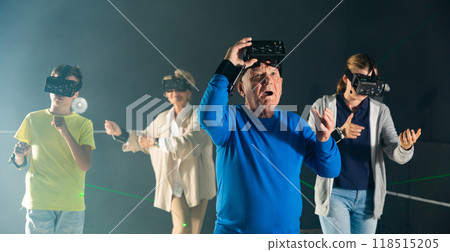 Astonished old man playing VR games with his family 118515205