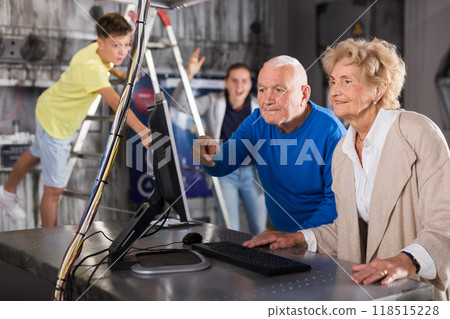 Senior man and woman with grandkids in escape room 118515228