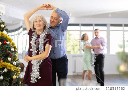 In studio decorated for New Year, elderly man and woman perky dance pair discofox. In studio decorated for New Year, elderly man and woman perky dance pair discofox. 118515262