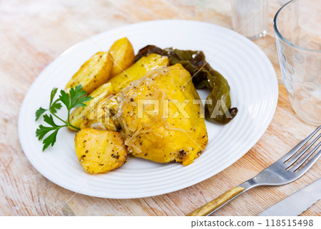 Appetizing fried chicken thigh with sliced potatoes, baked bell pepper and onions decorated with fresh of greenery on plate Appetizing fried chicken thigh with sliced potatoes, baked bell pepper and onions decorated with fresh of greenery on plate 118515498