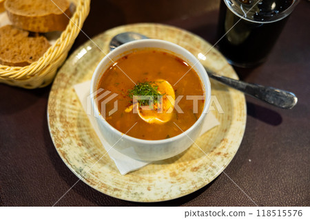 Popular dish of Russian cuisine is pickle soup with meat, cooked on basis of pickled cucumbers and pearl barley closeup 118515576