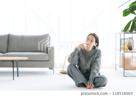 一個女人坐在客廳地板上放鬆 118516003