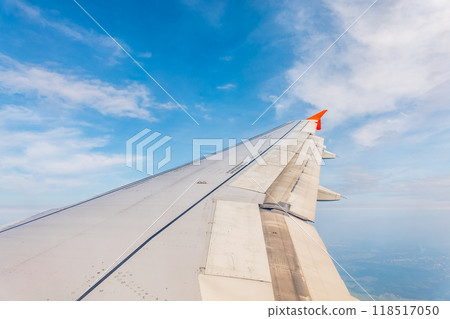 View from the airplane window at a beautiful cloudy sky and the airplane wing 118517050