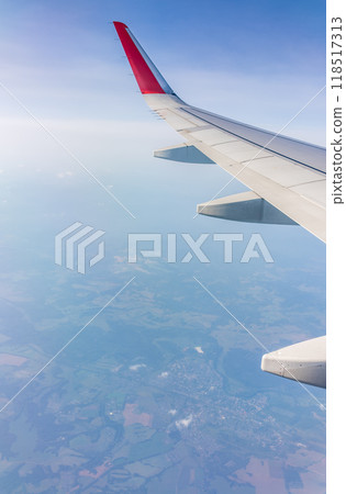 View from the airplane window at a beautiful cloudy sky and the airplane wing 118517313