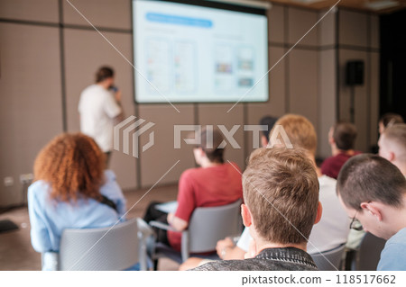 Audience listening to speaker during engaging business presentation Audience listening to speaker during engaging business presentation 118517662