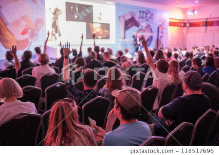 Audience engaged in lively conference with speaker on stage Audience engaged in lively conference with speaker on stage 118517696