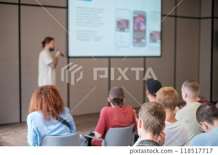 Speaker presenting in modern conference room with engaged audience Speaker presenting in modern conference room with engaged audience 118517717