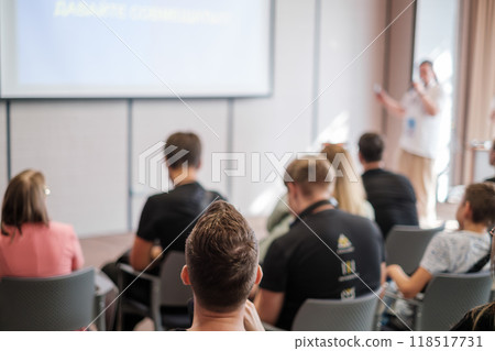 Audience attentively listening to a presentation in a modern conference room Audience attentively listening to a presentation in a modern conference room 118517731