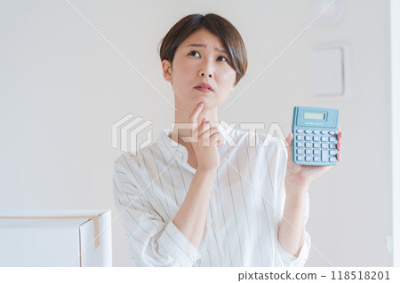 A woman estimating moving costs on a calculator A woman estimating moving costs on a calculator 118518201