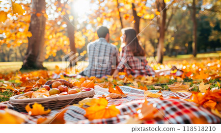 Autumn picnic with couple in park surrounded by colorful leaves and sunshine Autumn picnic with couple in park surrounded by colorful leaves and sunshine 118518210
