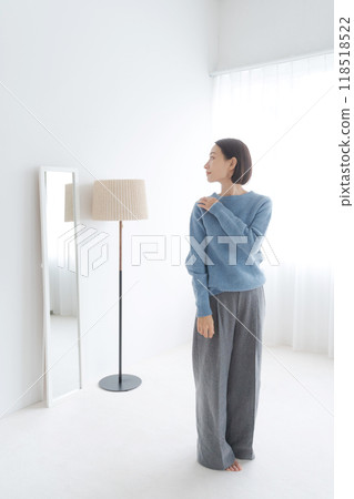 一個女人在鏡子裡檢查自己的外表 118518522