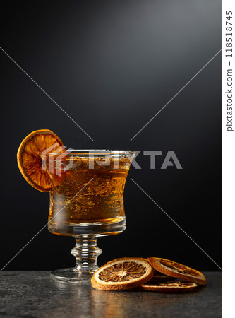 Rum or whiskey in a glass on a black background. 118518745