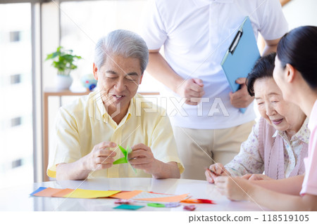 Care image: Seniors and caregivers folding origami 118519105