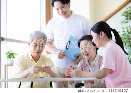 Care image: Seniors and caregivers folding origami Care image: Seniors and caregivers folding origami 118519107