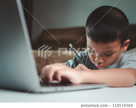Technology studying at home using laptop computer, Student distance learning virtual distance online class on video call virtual lesson, Parent or tutor teaching child boy with remote education. Technology studying at home using laptop computer, Student distance learning virtual distance online class on video call virtual lesson, Parent or tutor teaching child boy with remote education. 118519369
