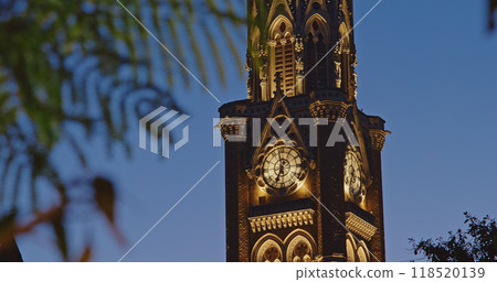 Close-up view on Rajabai Clock Tower In Evening Illumination. Clock Tower In Mumbai India. Confines Of Fort Campus Of University Of Mumbai. It Stands At Height Of 85 M or 280 Ft. Modeled It On Big Ben 118520139
