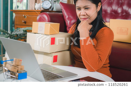Asia women working business SME online at home her checking order from laptop for customer and online delivery for ready packing, Checking orders from customers with digital laptop, Small business. 118520261