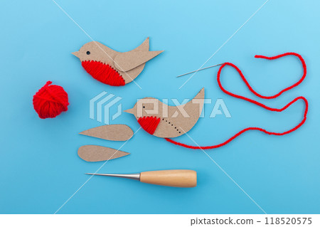 a couple of paper birds sitting on top of a table, yarn, cut out of cardboard, stitches, 118520575
