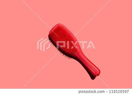 Bold Simplicity, plastic hairbrush takes center stage against a crimson backdrop Bold Simplicity, plastic hairbrush takes center stage against a crimson backdrop 118520597