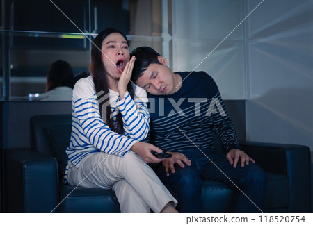 sleepy couple yawning and sleeping while watching TV movie on sofa at night sleepy couple yawning and sleeping while watching TV movie on sofa at night 118520754