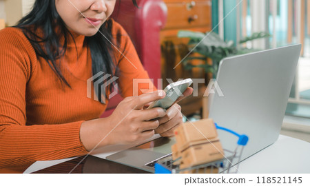 Asia women working business SME online at home her checking order from smartphone  for customer and online delivery for ready packing, Checking orders from customers with digital laptop. 118521145