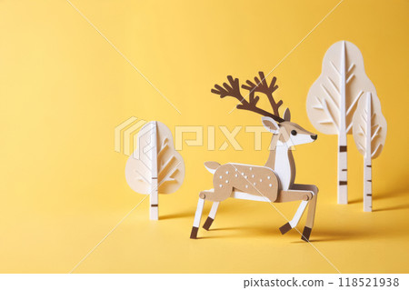 Paper craft deer on yellow background, 3/4 view, featuring brown and white color scheme. Folk art style with cardboard cutout and birch details in miniature photo 118521938