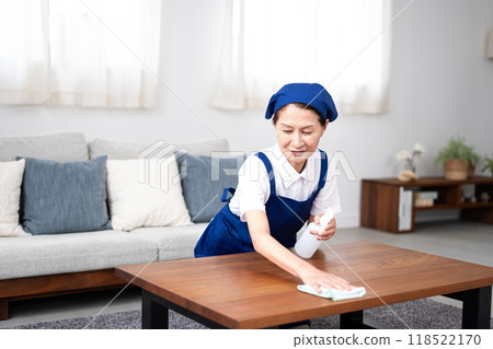 Senior female housekeeper in a white polo shirt with a blue apron Senior female housekeeper in a white polo shirt with a blue apron 118522170
