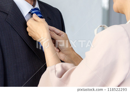 My wife tightening a husband's necktie 118522293