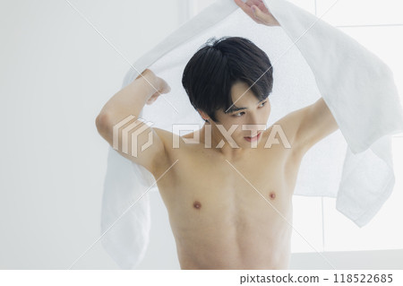 一名裸體青年用浴巾擦拭身體 118522685