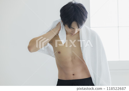A naked young man wiping his body with a bath towel A naked young man wiping his body with a bath towel 118522687