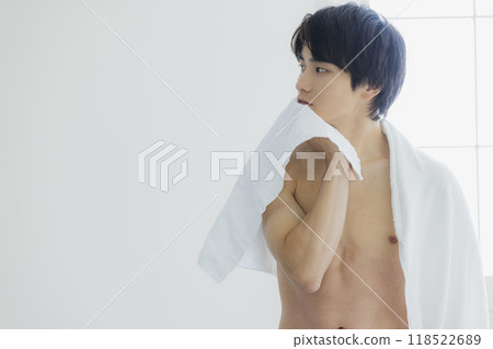 A naked young man wiping his body with a bath towel A naked young man wiping his body with a bath towel 118522689