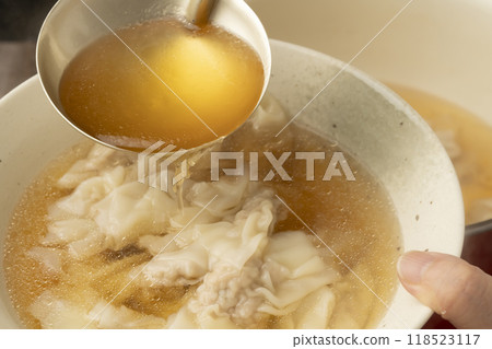 Wonton: Place wonton soup in a bowl 118523117