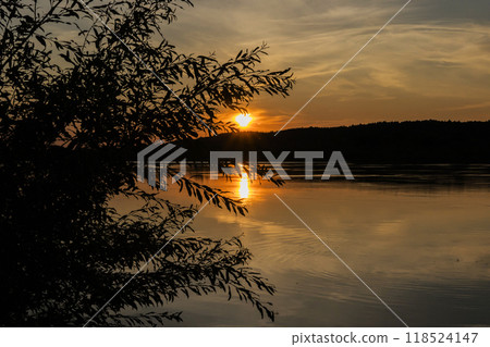 The sun is slowly setting over a beautiful body of water 118524147