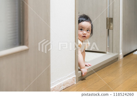 [A baby with tied hair crawling in the hallway peeks in] 118524260